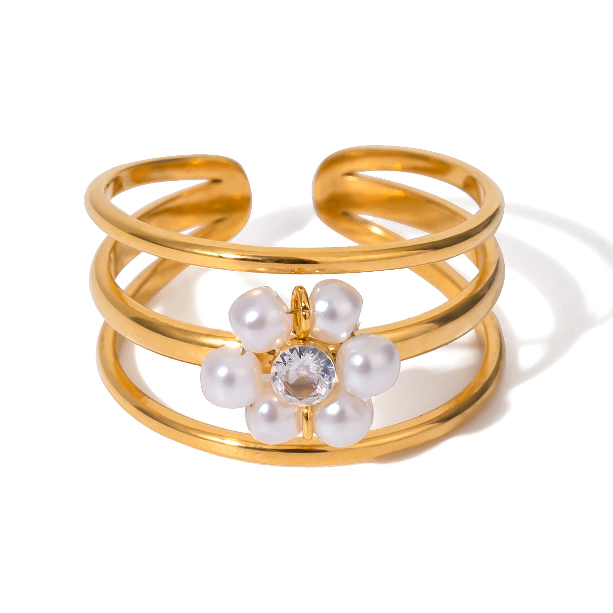 Gold stainless steel ring with pearl flower design on a white background