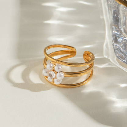 Gold ring with pearls and crystals on a light surface