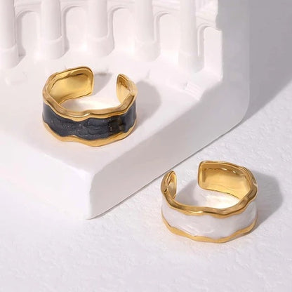 Two gold and black tarnish-free rings on a white surface