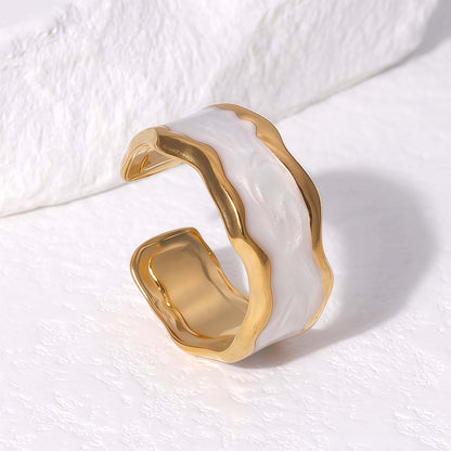 Gold and white ring on a textured white surface