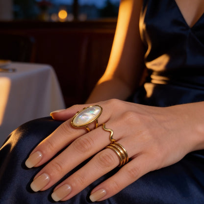 Close-up of a hand wearing gold rings with a blurred background