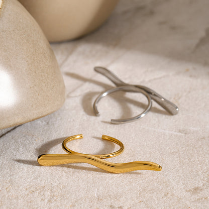 Gold and silver rings on a textured beige surface