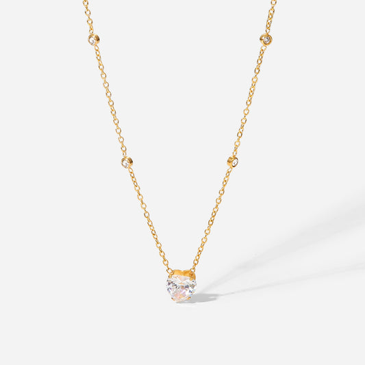 Gold necklace with a clear gemstone pendant on a white background