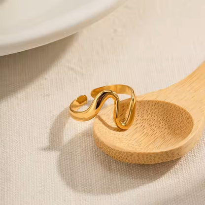 Gold stainless steel ring on a wooden spoon with a neutral background