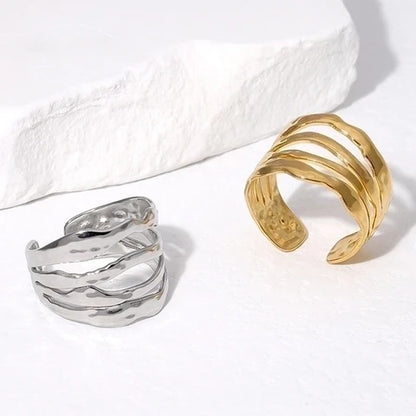 Gold and silver open rings on a textured white surface
