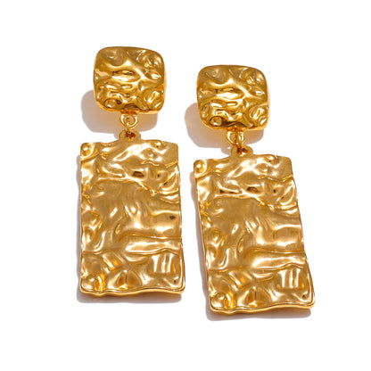 Pair of gold statement earrings with textured design on a white background