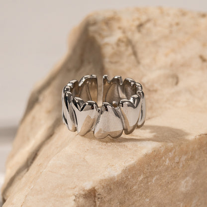 Silver ring with a unique design on a beige stone surface