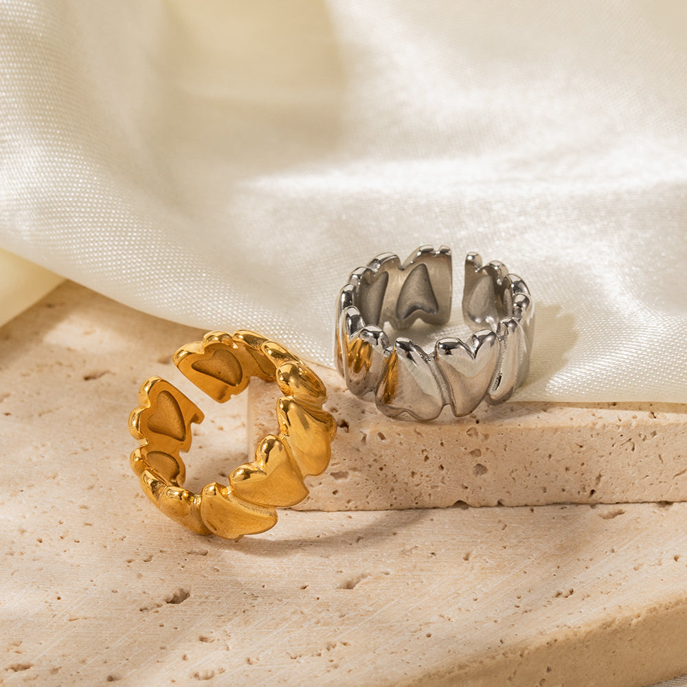 Gold and silver rings on a textured surface with a soft fabric background