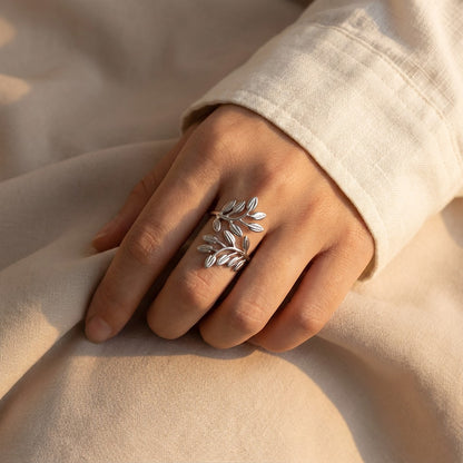 silver stainless steel ring with leaf design on woman's hand