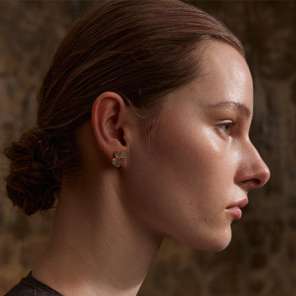 Close-up of a person wearing an earring with a textured background