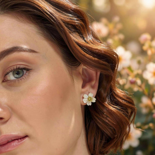 Close-up of a woman wearing a floral earring with a blurred natural background