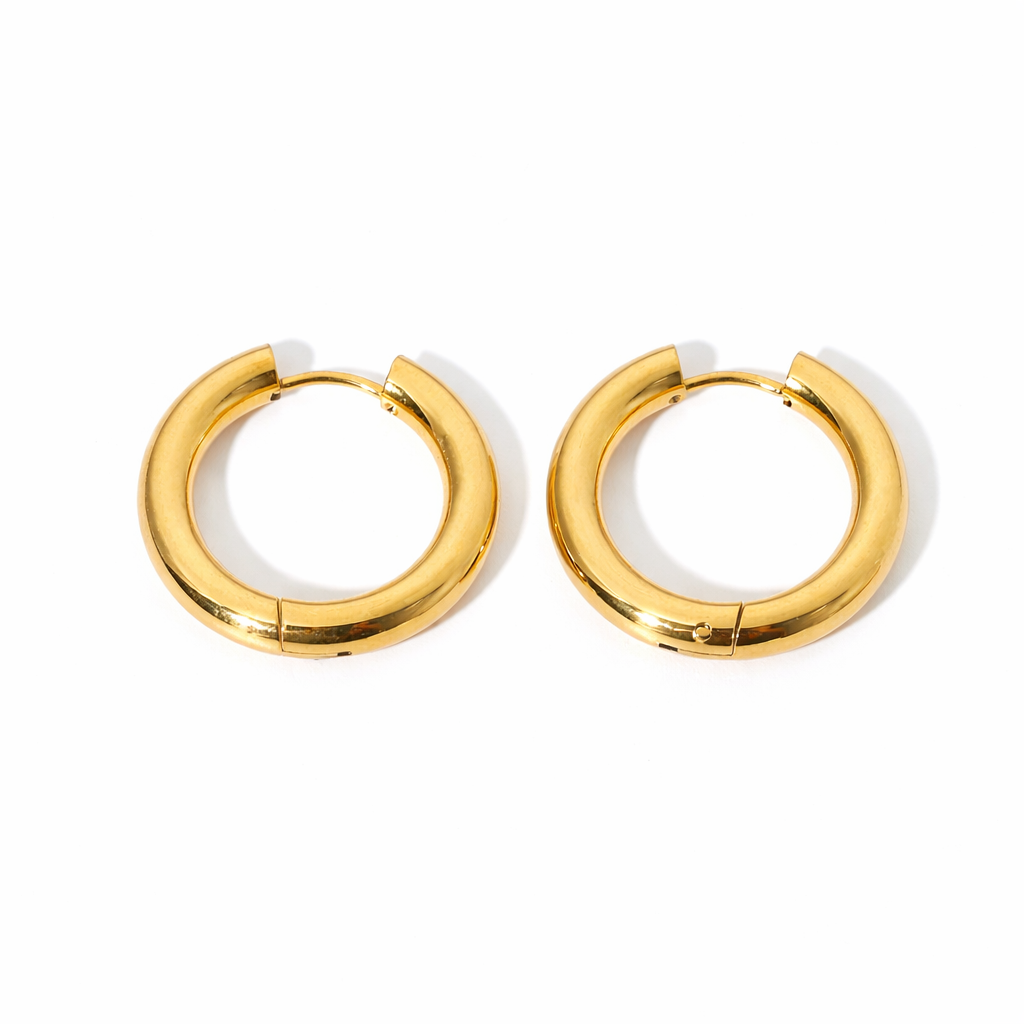 Pair of simple gold hoop earrings on a white background