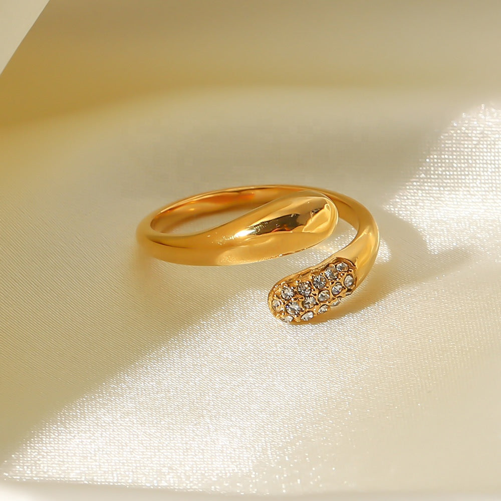 Gold ring with diamond accents on a beige fabric background