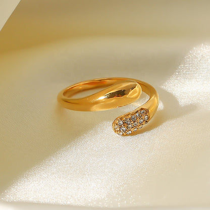 Gold ring with diamond accents on a beige fabric background