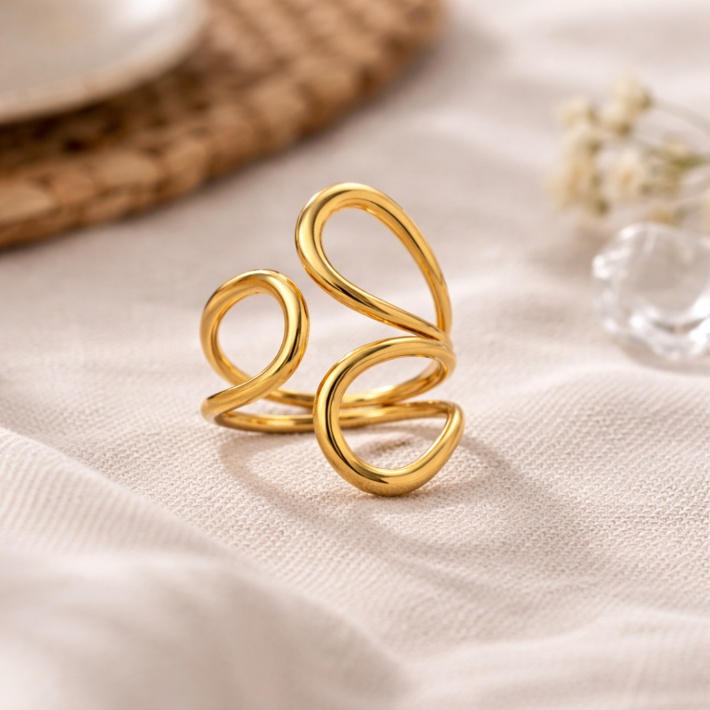 Gold spiral ring on a beige fabric surface
