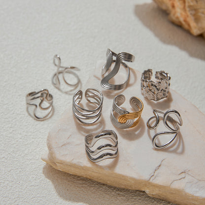 Set of silver and gold tarnish-free rings on a stone surface
