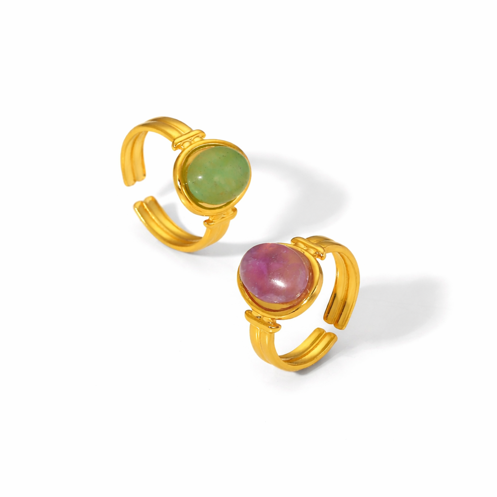 Two gold rings with gemstones on a white background