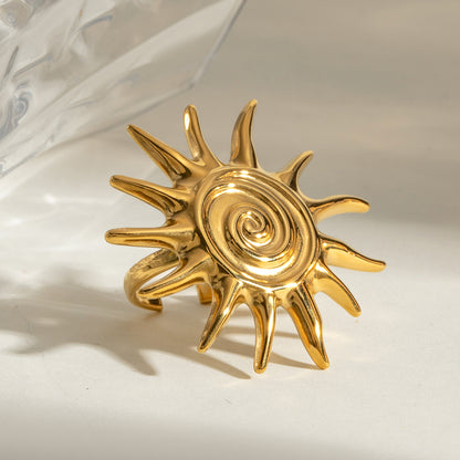 Gold sun-shaped ring on a light background