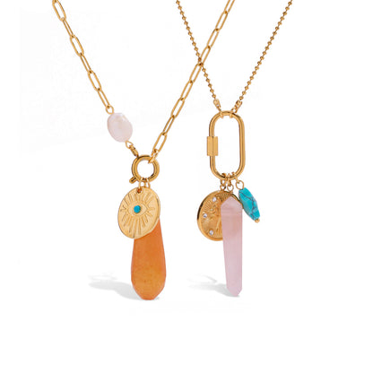 Two gold necklaces with various pendants on a white background