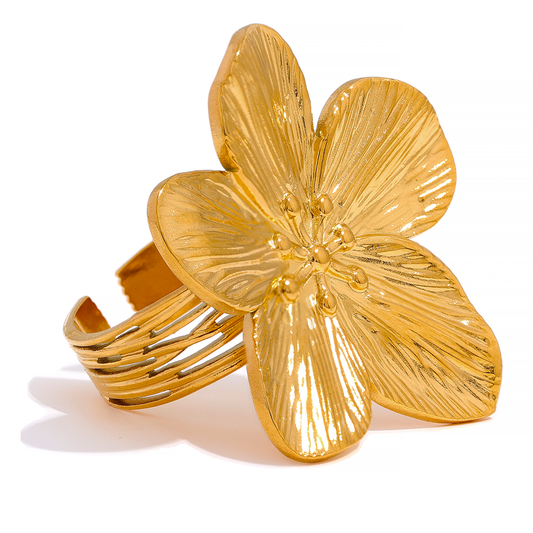 Gold flower-shaped ring on a white background
