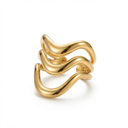 Gold statement ring with wavy design on a white background