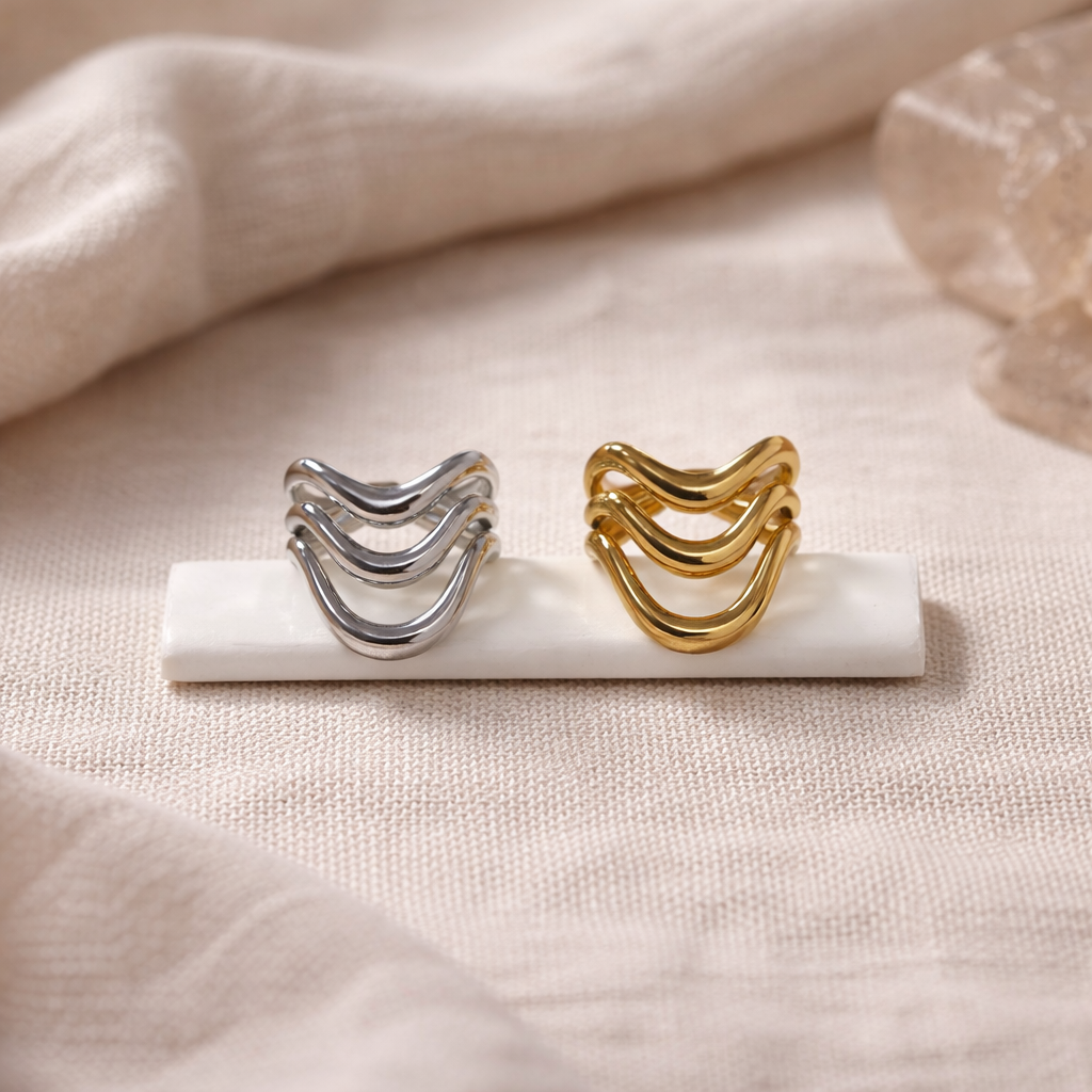 Gold and silver rings on a marble stand with a soft beige background