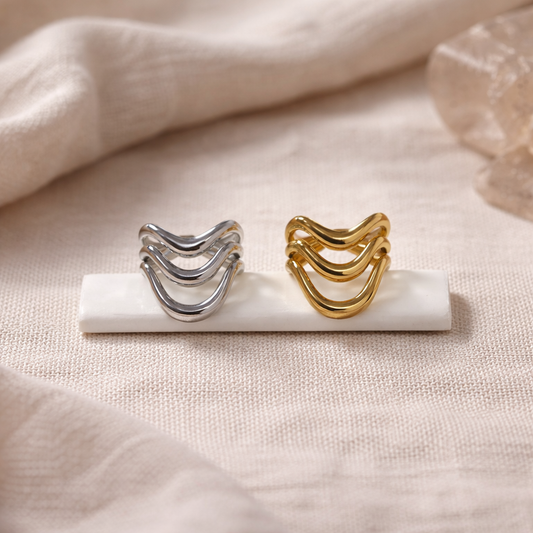 Gold and silver rings on a marble stand with a soft beige background