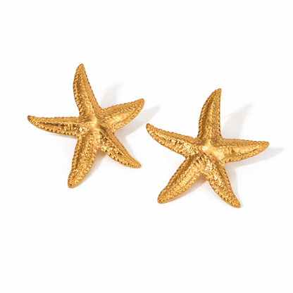 Gold starfish earrings on a white background