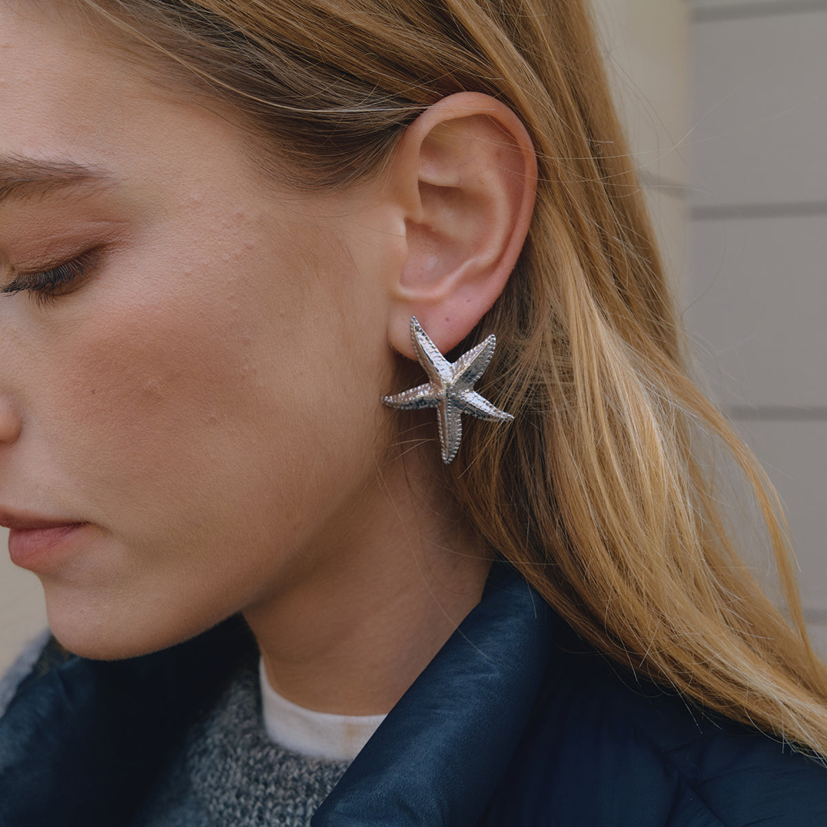 Close-up of a woman wearing starfish-shaped earrings.