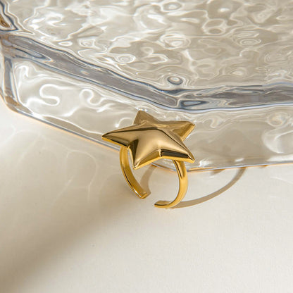 Gold star-shaped ring on a textured silver dish
