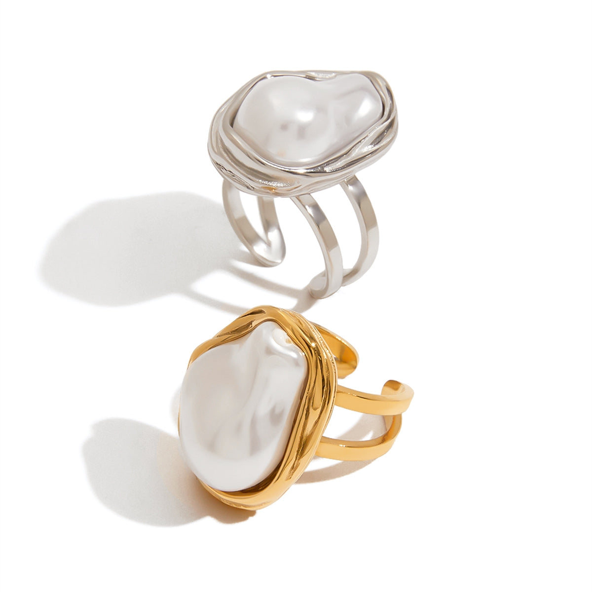 Two rings with pearl-like stones on a white background