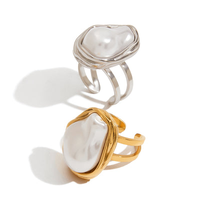 Two rings with pearl-like stones on a white background