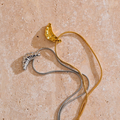 Gold and silver water-resistant necklaces on a beige stone surface