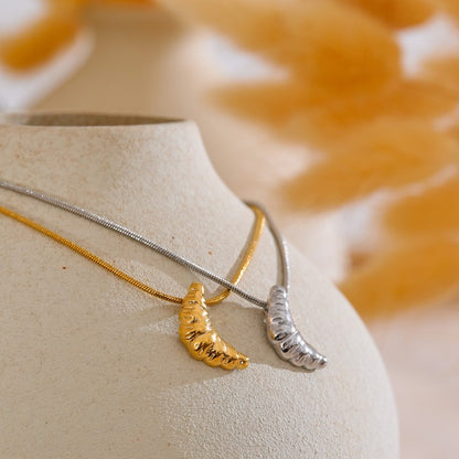 Two necklaces with unique pendants on a neutral background