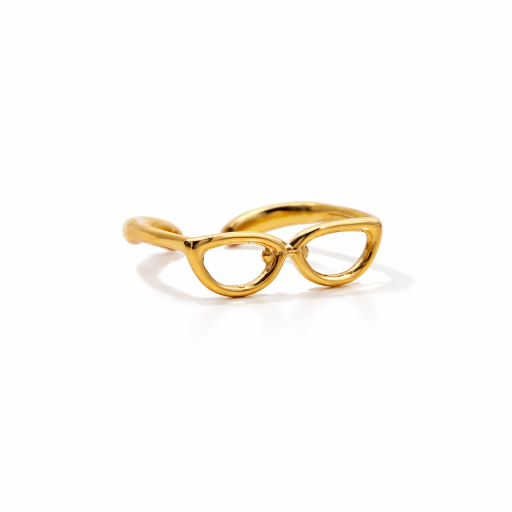 Gold eyeglass-shaped ring on a white background