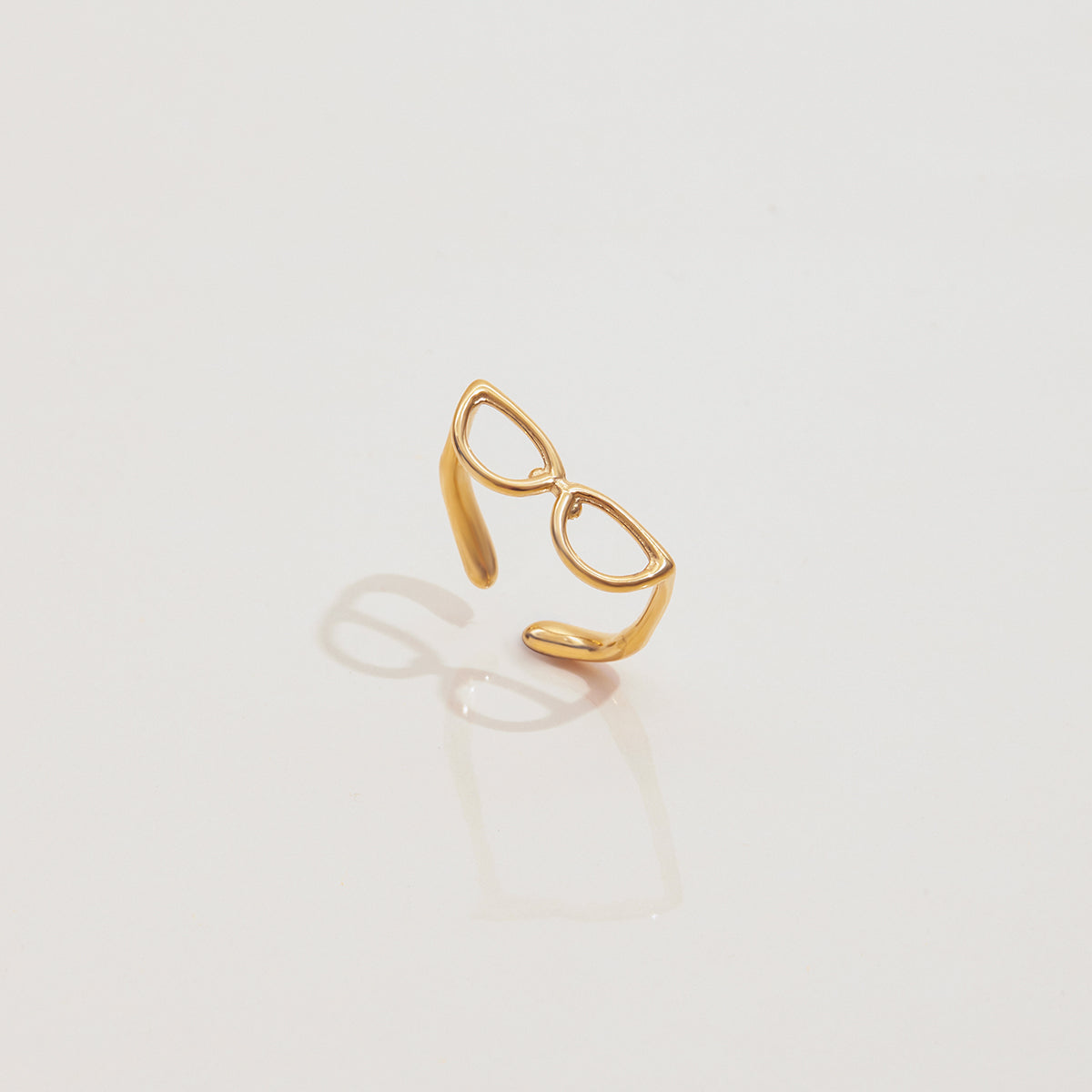 Gold ring with a unique design on a light gray background