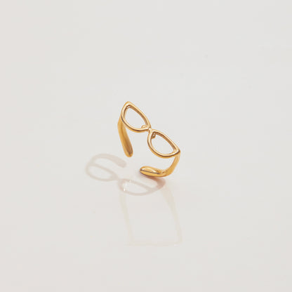 Gold ring with a unique design on a light gray background