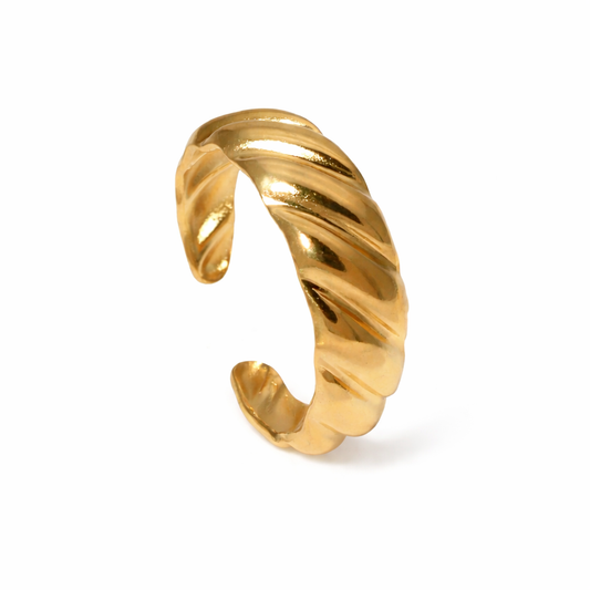 Gold twisted ring on a white background
