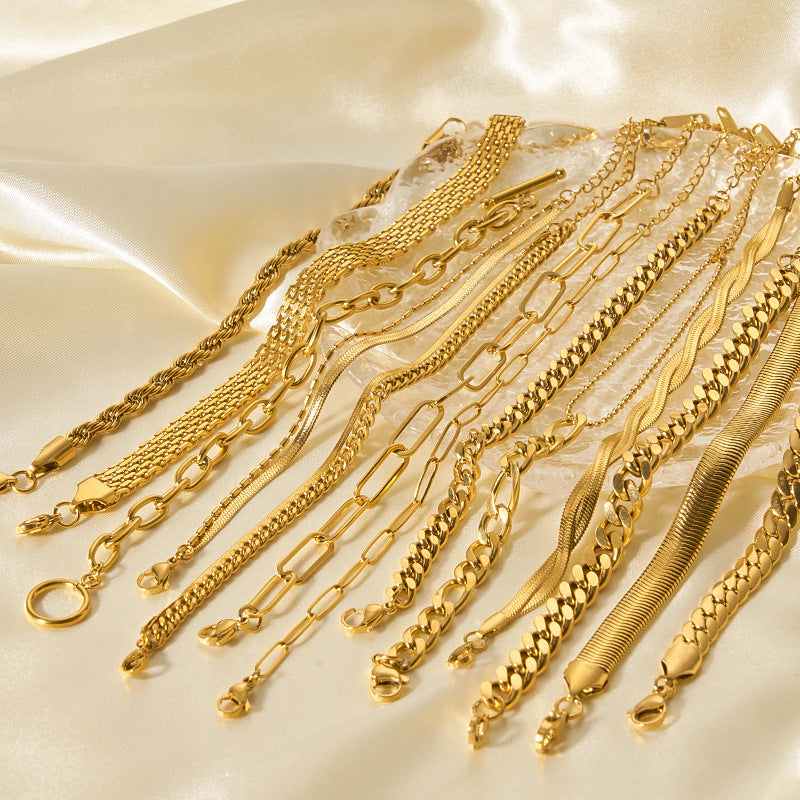 Collection of gold bracelets on a beige fabric background
