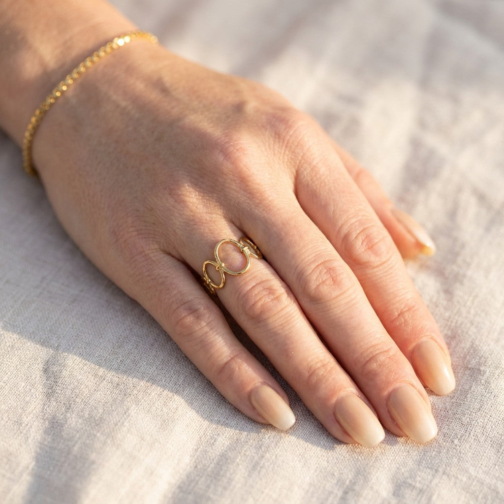 hand wearing a gold ring and bracelet
