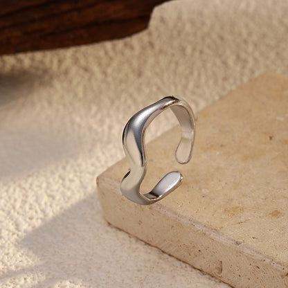 minimalist silver ring on beige background