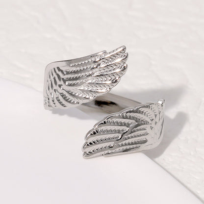 Silver wing-shaped ring on a light background