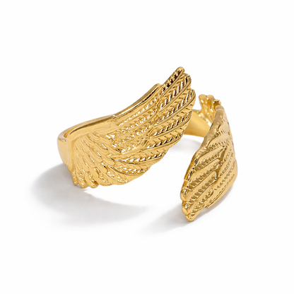 Gold wing-shaped ring on a white background