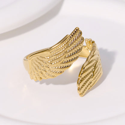 Gold wing-shaped tarnish-free ring on a white background