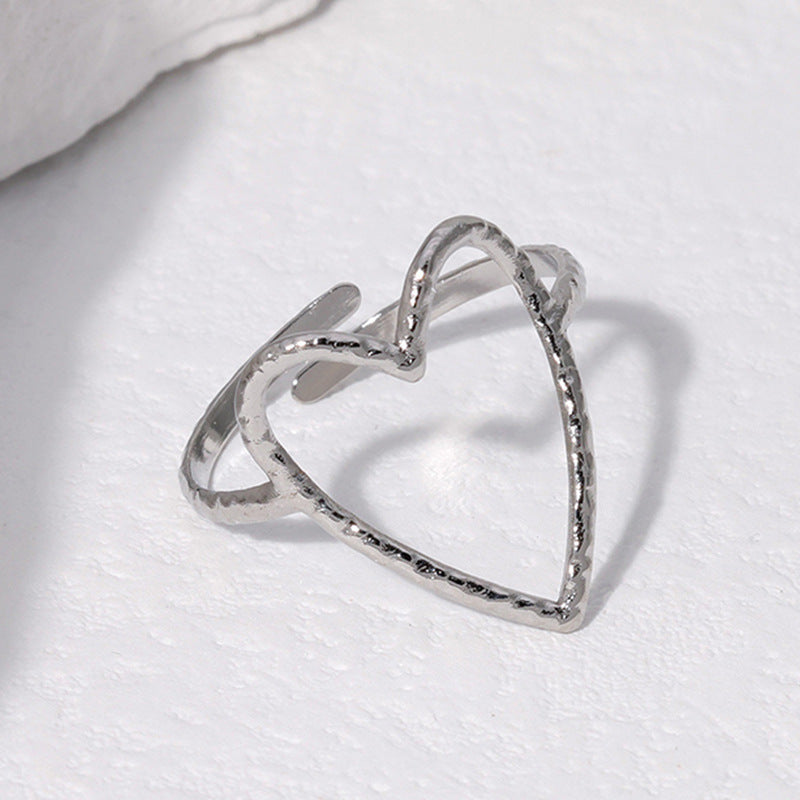 Silver heart-shaped ring on a white fabric background